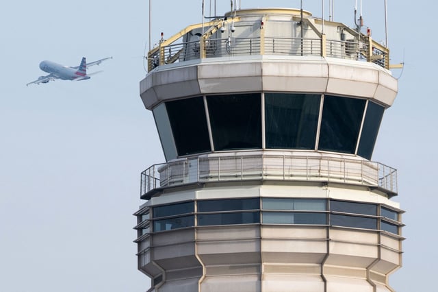 An American Airlines Airbus A319 airplane takes off past the air traffic control tower at Ronald Reagan Washington National Airport in Arlington, Virginia, January 11, 2023. The US Federal Aviation Authority  said Wednesday that normal flight operations "are resuming gradually" across the country following an overnight systems outage that grounded departures. (Photo by SAUL LOEB / AFP) (Photo by SAUL LOEB/AFP via Getty Images)