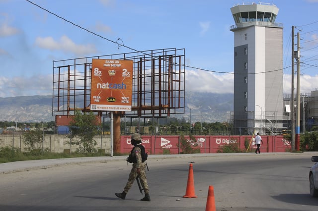 FILE - A police officer patrols the entrance of the Toussaint Louverture International Airport, in Port-au-Prince, Haiti, Nov. 12, 2024. (AP Photo/Odelyn Joseph, File)