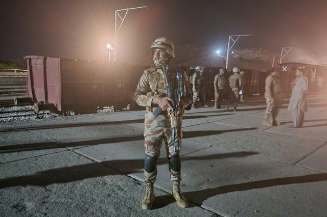 Pakistani soldiers secure Mach railway station after Pakistani security forces freed some of the passengers from an ambushed train held hostage by armed rebels in the southwestern province of Balochistan