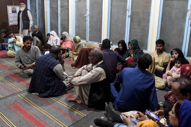 Passengers, who were rescued from a train after it was attacked by separatist militants, sit at the Mach Railway Station in Mach, Balochistan, Pakistan, March 11, 2025. REUTERS/Stringer