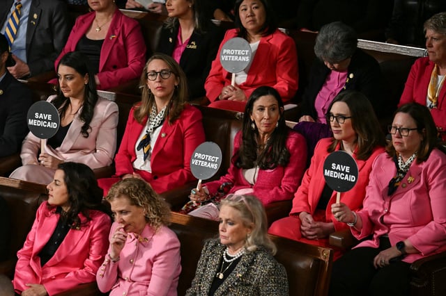 Democratic members of Congress hold up signs reading &#34;Save Medicaid&#34; and &#34;Protect Veterans&#34; as President Donald Trump speaks during an address to a joint session of Congress in the House Chamber of the U.S. Capitol in Washington, D.C., on March 4, 2025.