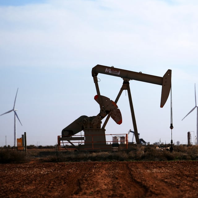 Wind turbines give backdrop to a pumpjack on a filed Wednesday, Feb. 26, 2025, in Lamesa, Texas. (AP Photo/Julio Cortez)