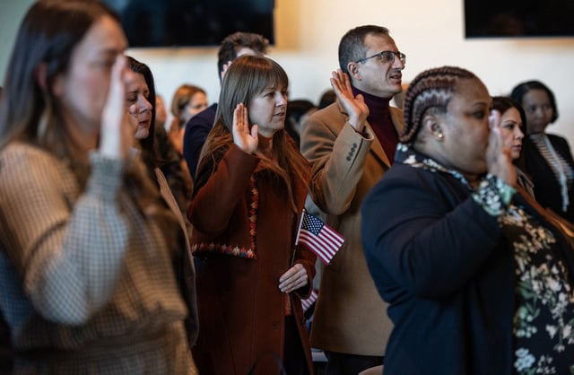 Immigrants take the oath of allegiance to the United State during a naturalization ceremony in the jury assembly room at the John Joseph Moakley United States Courthouse in Boston, Massachusetts on January 8, 2025. In total 102 immigrants from 40 countries became US citizens during the ceremony. 