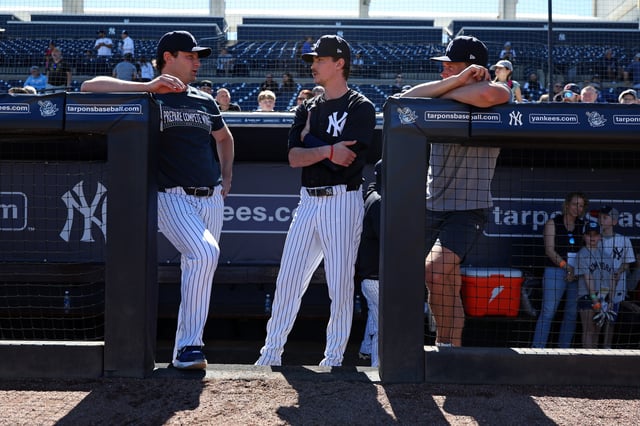 TAMPA, FL - FEBRUARY 17: Gerrit Cole #45, Max Fried #54 and Will Warren #98 of the New York Yankees talk during spring training at George M. Steinbrenner Field on February 17, 2025 in Tampa, Florida.