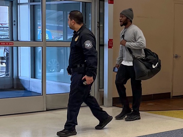 One of the six American prisoners flown from Kuwait to New York on Wednesday, March 12, 2025, right, is escorted by a Customs and Border Protection agent out of Terminal 7 at John F. Kennedy International Airport in New York. (AP Photo/Pamela Smith)