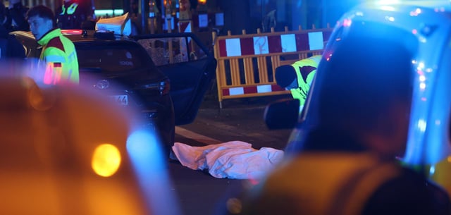 In der Düsseldorfer Innenstadt liegt eine tote Person abgedeckt neben einem Fahrzeug mit zersplittertem Fenster