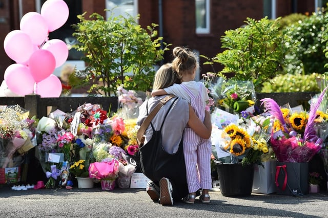 A mother hugs her child as they look at floral tributes for the victims of a deadly knife attack in Southport (Photo: PETER POWELL/AFP via Getty Images)