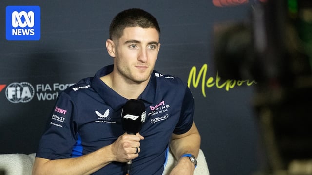 Jack Doohan holding a microphone, attending a press conference.