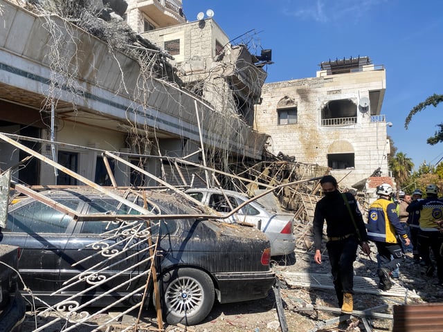 Civil defence members stands near a damaged site, after Israeli aircraft targeted a building on the edge of Damascus on Thursday, as reported by Syria's state news agency,in Damascus, Syria March 13, 2025. REUTERS/Firas Makdesi