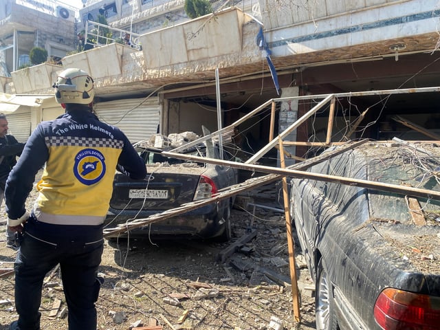 A civil defence member stands near a damaged site, after Israeli aircraft targeted a building on the edge of Damascus on Thursday, as reported by Syria's state news agency, in Damascus, Syria March 13, 2025. REUTERS/Firas Makdesi