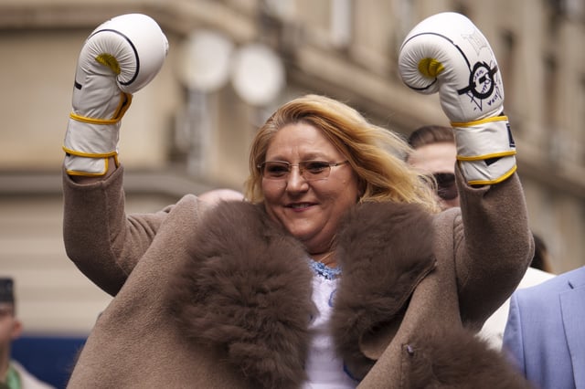 Controversial Romanian politician Diana Sosoaca, who was barred by a top court from entering last year's presidential election, raises her hands wearing boxing gloves as she arrives at the country's electoral authority to register in an unlikely bid to enter the May rerun in Bucharest, Romania, Thursday, March 13, 2025. (AP Photo/Vadim Ghirda)