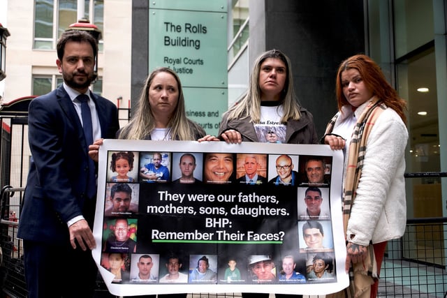 Victims of Brazilian dam collapse Gelvana Silva, Monia Dos Santos and Pamela Fernandes hold a banner with Mariana Mayor Juliano Duarte outside City Court House, Rolls Building ahead of the final day of the lawsuit against BHP in London, Britain, March 13, 2025. REUTERS/Marissa Davison
