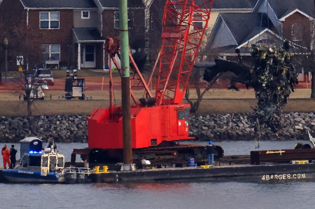 A crane retrieves part of the helicopter from the Potomac River, in the aftermath of the collision of American Eagle flight 5342 and a Black Hawk helicopter that crashed into the river, by the Ronald Reagan Washington National Airport, in Arlington, Virginia, U.S., February 6, 2025. REUTERS/Eduardo Munoz/File Photo