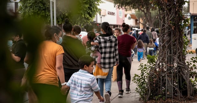 Migrants walk from a DHS tent facility in front of the McAllen bus station to Catholic Charities RGV Humanitarian Respite Center on April 22, 2021.