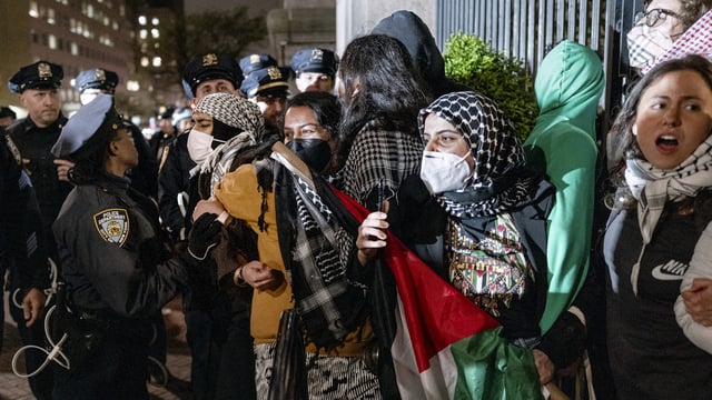 Demonstrators hold their ground near a main gate at Columbia University in New York, Tuesday, April 30, 2024, as New York City police officers move to clear the area after a building was taken over by pro-Palestinian protesters earlier in the day. (AP Photo/Craig Ruttle, File)