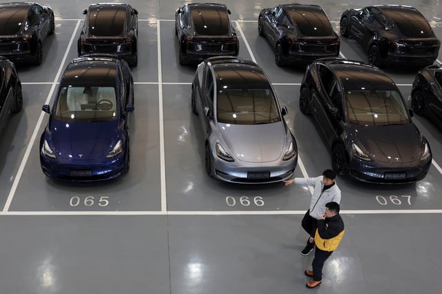 People walk past Tesla electric vehicles (EV) at the carmaker's delivery centre in Beijing, China January 8, 2025. REUTERS/Florence Lo/File Photo