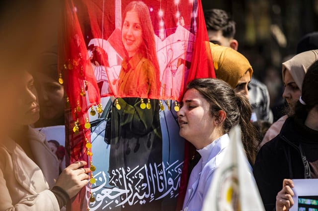 A woman reacts next to one of the pictures of victims of a recent wave of sectarian violence targeting Syria&#39;s Alawite minority in the west of the country along the Mediterranean sea coast, during a protest condemning the attacks in Syria&#39;s northeastern city of Qamishli on March 11, 2025.