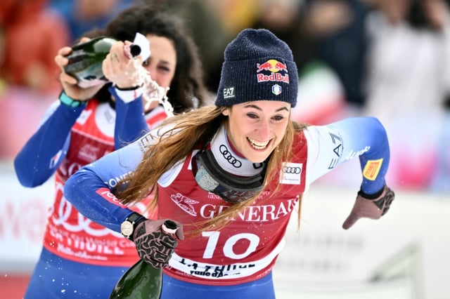 Italy's Federica Brignone (L) celebrates with Italy's Sofia Goggia, second, on the podium of the women's super-G