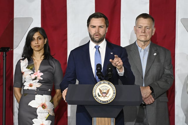 Vice President JD Vance, center, speaks at a rally about "America's industrial resurgence," as he is flanked by his wife, Usha Vance, left, and Vantage Plastics President Paul Aultman, Friday, March 14, 2025, at Vantage Plastics in Bay City, Mich. (AP Photo/Jose Juarez)