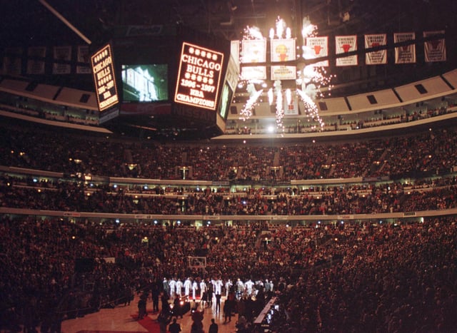 The Chicago Bulls team watches as the 1997 NBA Championship banner is revealed with a shower of fireworks prior to the 01 November game against the Philadelphia 76&#39;ers, at the United Center in Chicago, IL.