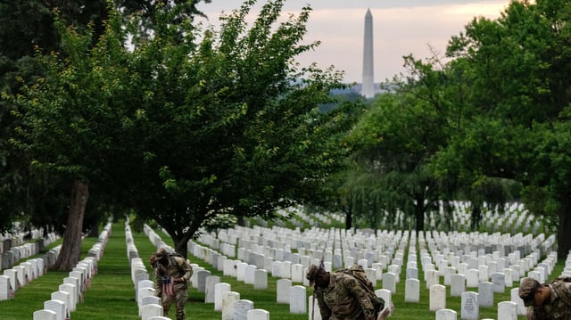 ARLINGTON, VIRGINIA - MAY 23: Members of the 3rd U.S. Infantry Regiment, also known as the &#34;Old Guard,&#34; place flags at the headstones of U.S. military personnel buried at Arlington National Cemetery ahead of Memorial Day, on May 23, 2024 in Arlington, Virginia.