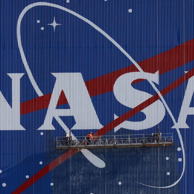 Painters refurbishing the NASA logo the space agency's Vehicle Assembly Building at the Kennedy Space Center 