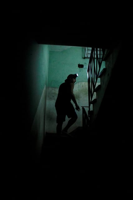 Davianis Deyunde walks up the stairs of his home during a national electrical grid collapse, in Havana, Cuba, March 14, 2025. REUTERS/Norlys Perez