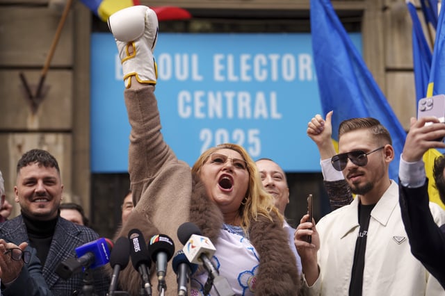Controversial politician Diana Sosoaca, who was barred by a top court from entering last year's presidential election, raises her hands wearing boxing gloves and speaking outside the country's electoral authority after she registered an unlikely bid to enter the May rerun in Bucharest, Romania, Thursday, March 13, 2025. (AP Photo/Vadim Ghirda)