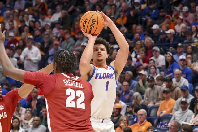 Mar 15, 2025; Nashville, TN, USA;  Florida Gators guard Walter Clayton Jr. (1) shoots over Alabama Crimson Tide forward Aiden Sherrell (22)during the first half at Bridgestone Arena. Mandatory Credit: Steve Roberts-Imagn Images