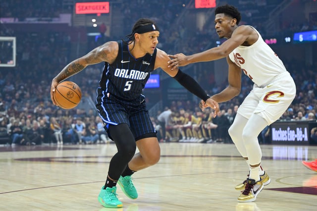 Mar 16, 2025; Cleveland, Ohio, USA; Orlando Magic forward Paolo Banchero (5) dribbles beside Cleveland Cavaliers forward De'Andre Hunter (12) in the first quarter at Rocket Arena.