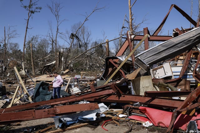 Friends and family members search for belongings in the damage after a tornado passed through the area, Sunday, March 16, 2025, in Plantersville, Ala. (AP Photo/Butch Dill)
