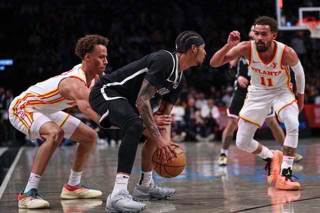 Mar 16, 2025; Brooklyn, New York, USA; Brooklyn Nets guard Keon Johnson (45) is defended by Atlanta Hawks guard Dyson Daniels (5) and guard Trae Young (11) during the second half at Barclays Center. Mandatory Credit: Vincent Carchietta-Imagn Images