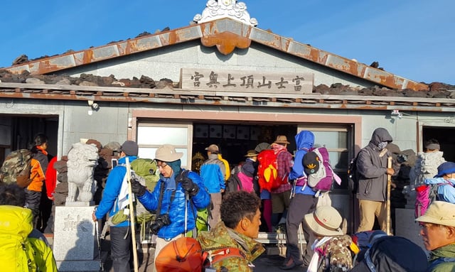 A crowd at the Shinto shrine at the top of Mount Fuji. The fee to access its Fujinomiya, Gotemba, Subashiri and Yoshida trails will increase to 4,000 yen this year. Photo: Shutterstock
