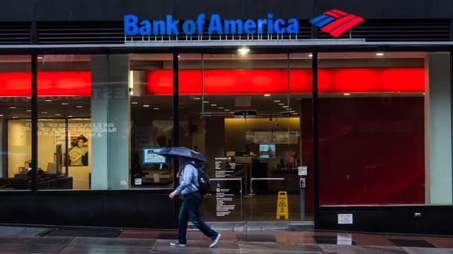 A pedestrian walks past a Bank of America location. 