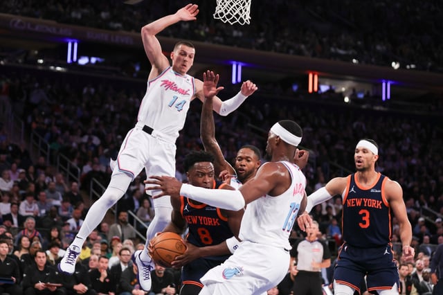 New York Knicks forward OG Anunoby (8) is surrounded by Miami Heat defenders, including center Bam Adebayo (13) and guard Tyler Herro (14), during the first half of an NBA basketball game, Monday, March 17, 2025, in New York. (AP Photo/Heather Khalifa)