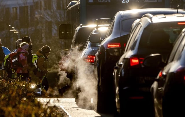 Cars release exhaust fumes as children head to school in Frankfurt, Germany, Feb. 27, 2023.
