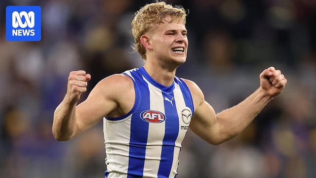 Jackson Archer lifts his arms up while grimacing