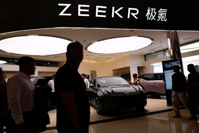 People walk past a booth of Zeekr, Chinese automaker Geely's premium electric vehicle (EV) brand, at a shopping mall in Beijing, China November 3, 2023. REUTERS/Tingshu Wang/File Photo