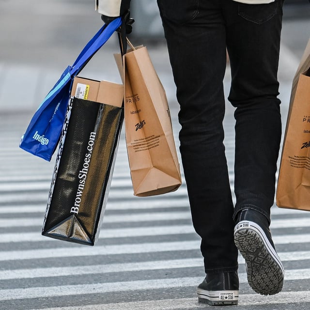 A person carries shopping bags along a street in Montreal, Saturday, December 14, 2024. February's inflation release from Statistics Canada will reveal the impact of an unwinding of the two-month federal sales tax break. THE CANADIAN PRESS/Graham Hughes