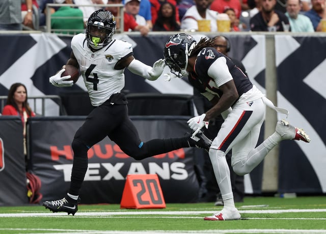 Sep 29, 2024; Houston, Texas, USA; Jacksonville Jaguars running back Tank Bigsby (4) stiff arms Houston Texans cornerback Jeff Okudah (11) in the second half at NRG Stadium. Mandatory Credit: Thomas Shea-Imagn Images/File Photo