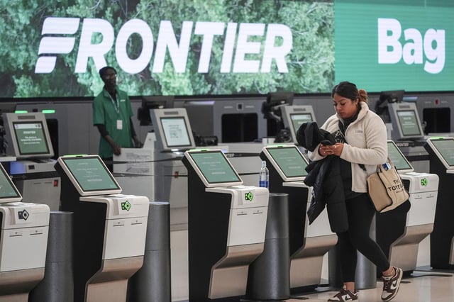 A traveller prepares to use a kiosk to check in for a flight on Frontier Airlines in Denver in 2024.