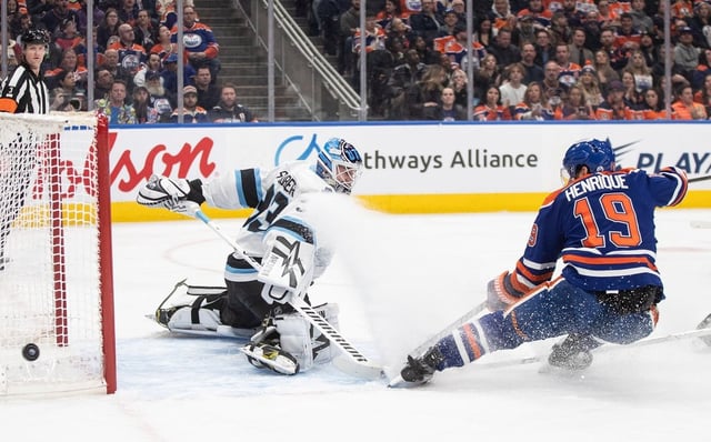 Utah Hockey Club goalie Jaxson Stauber (33) makes the save on Edmonton Oilers' Adam Henrique (19) during second period NHL action in Edmonton on Tuesday, March 18, 2025. THE CANADIAN PRESS/Jason Franson
