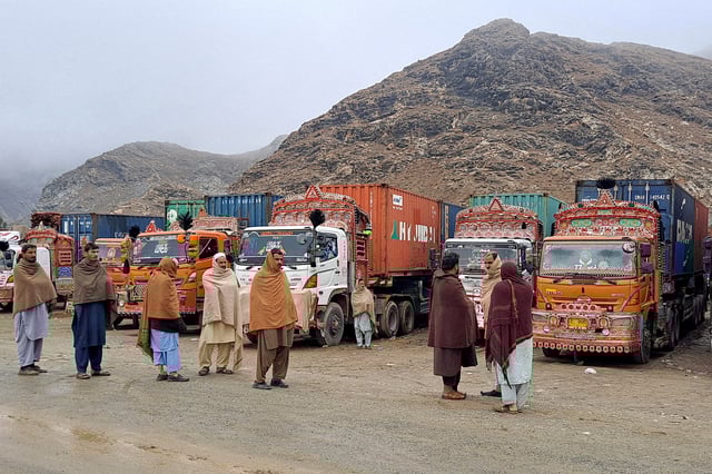 People stand next to parked trucks loaded with supplies at the Torkham border crossing following the closure of the border crossing between Pakistan and Afghanistan, March 3, 2025. REUTERS/Shahid Shinwari/File Photo
