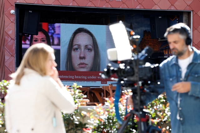 Members of the media work near a large screen showing a picture of convicted hospital nurse Lucy Letby, ahead of her sentencing, outside the Manchester Crown Court, in Manchester, Britain, August 21, 2023. REUTERS/Phil Noble/File Photo