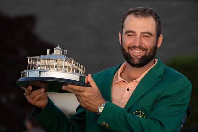Masters champion Scottie Scheffler poses for photos during the green jacket ceremony following the final round of the Masters Tournament.