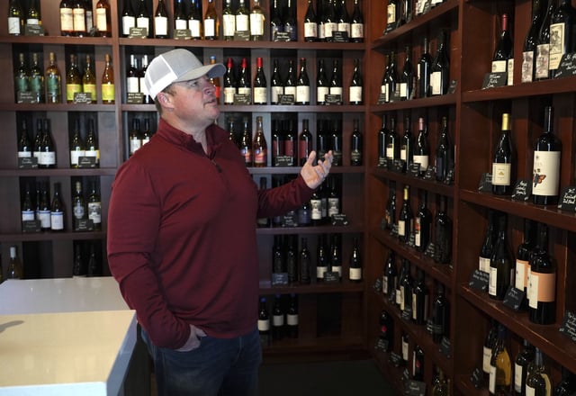Craig Ledbetter of Vino Farms looks at locally made wines at the Lodi Wine Visitor Center in Lodi, Calif. on March 18, 2025. (AP Photo/Terry Chea)