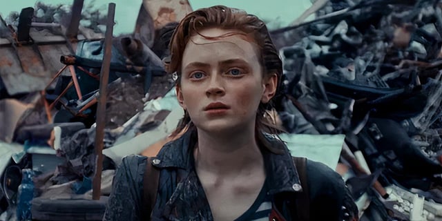 Sadie Sink in front of a trash pile in O'dessa