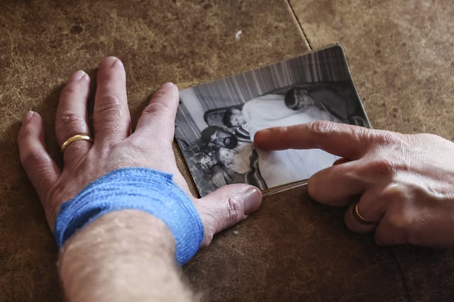 Jake Heinrichs holds a photo of his father who died from Alzheimer's, in New York, on Wednesday, March 12, 2025. (AP Photo/Heather Khalifa)