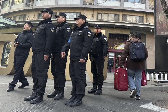 Chinese security personnel patrol the street near a meeting of family members of passengers who were on board the MH370 Malaysia Airline jet that went missing in 2014 in Beijing, China, Saturday, March 8, 2025. (AP Photo/Ng Han Guan)