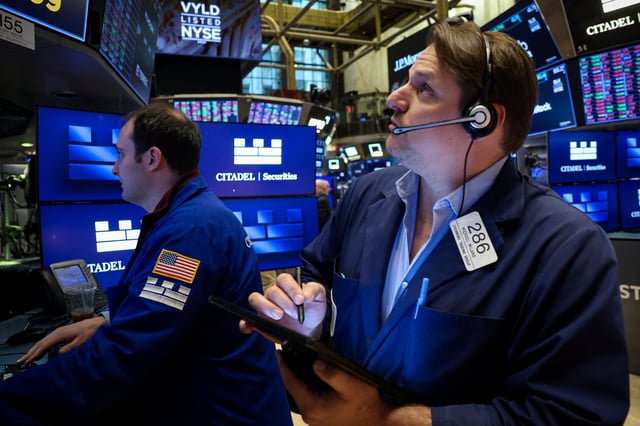 Traders work on the floor at the New York Stock Exchange (NYSE) in New York City, U.S., March 20, 2025.  REUTERS/Brendan McDermid/File Photo